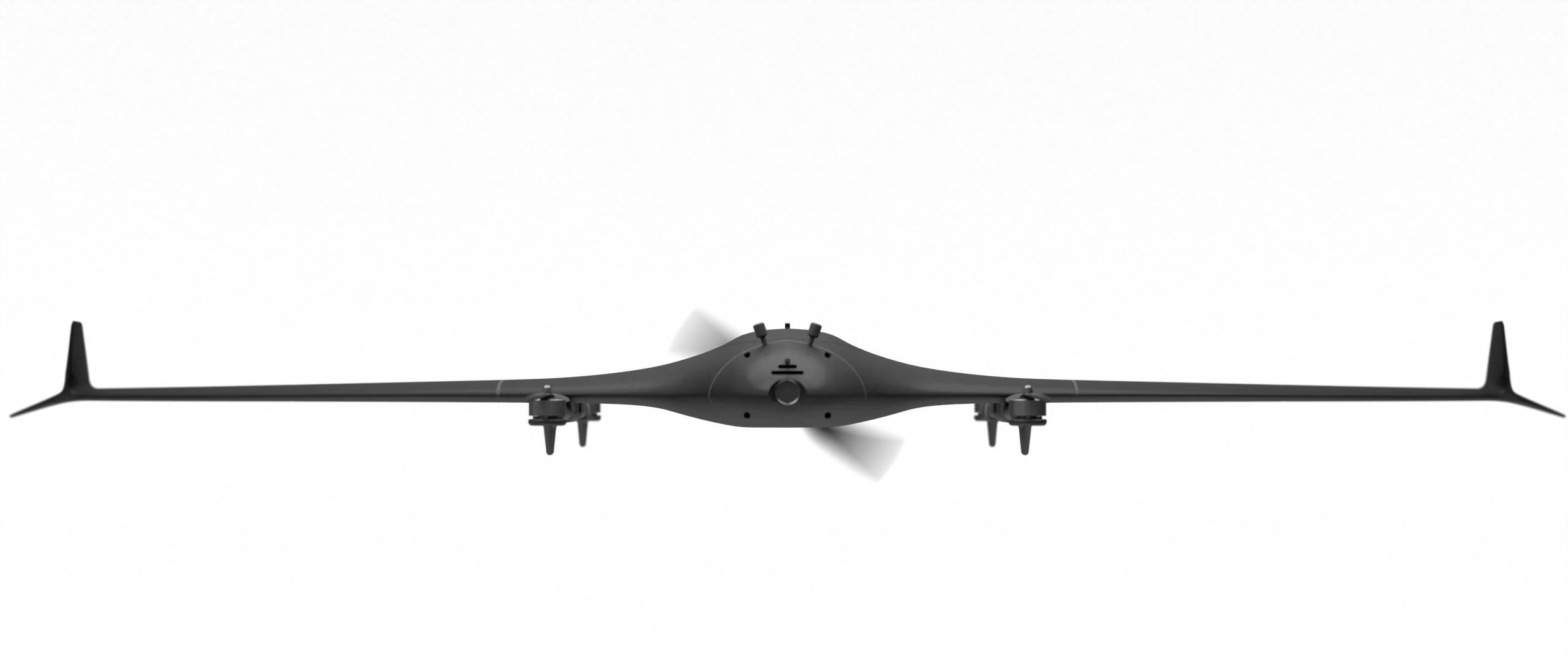 TerraHawk FPV seen head-on in the studio, a blended-wing aircraft with upswept wingtips, four lift rotors paired on two booms under the wing, and the pusher propeller turning behind the fuselage.